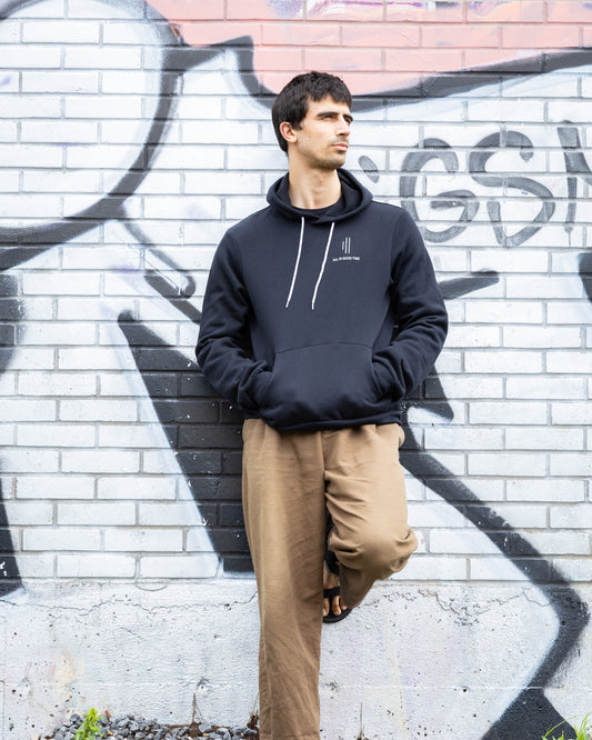 Man wearing the Cowbell & Groove hoodie featuring “All in Good Time” and graphic bars