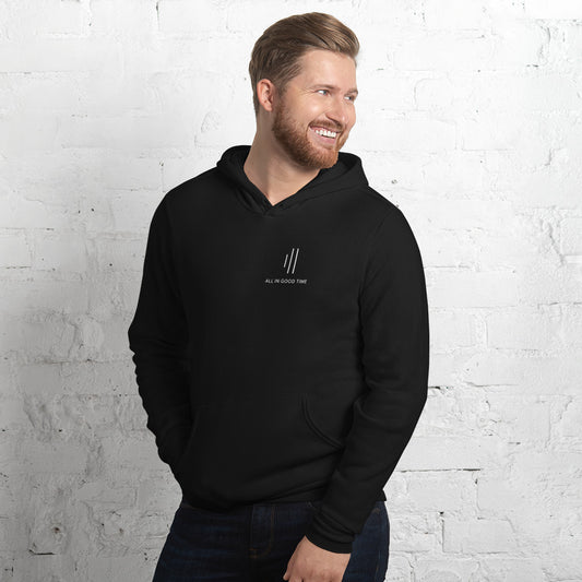 Man wearing black drummer hoodie by Cowbell & Groove, minimalist chest print with 'All in Good Time' and groove bar logo reinterpretation